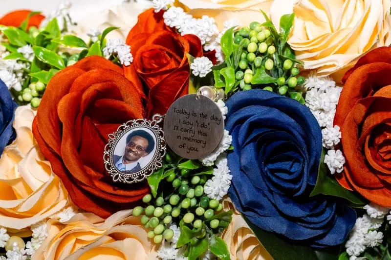 Close-up of memorial photo charms set among navy and orange roses