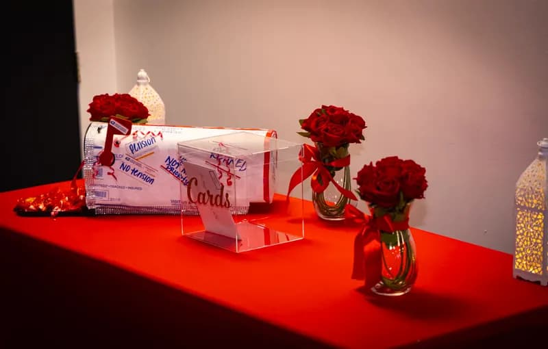 Gift and card table with red rose bud vases and lanterns