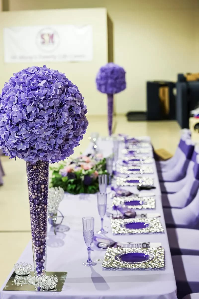 Prayer breakfast head table with lavender linens and a purple hydrangea tower centerpiece