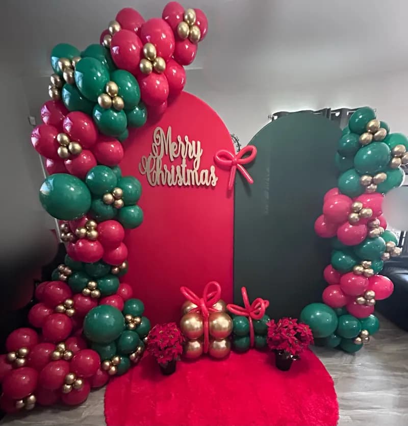'Merry Christmas' arch backdrop with red, green and gold balloon garland